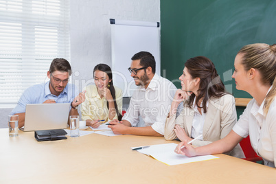 Casual business team having a meeting using laptop