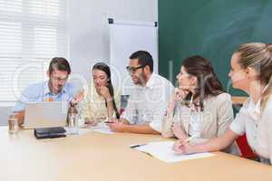 Casual business team having a meeting using laptop