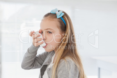 Small girl using her inhaler
