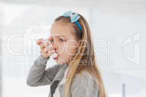 Small girl using her inhaler