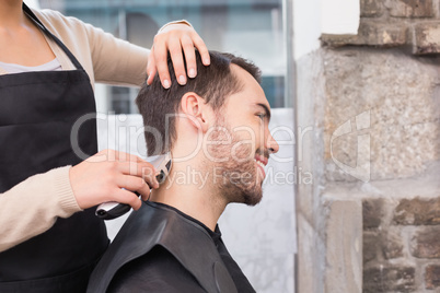 Handsome man getting his hair trimmed