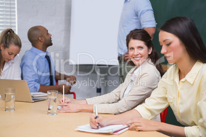 Business people taking notes at presentation