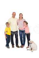 Happy family smiling at camera with pet dog