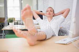 Businesswoman sitting with legs crossed at ankle on desk