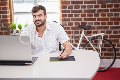 Casual designer using graphics tablet and laptop