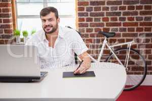 Casual designer using graphics tablet and laptop