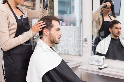 Hair stylist drying mans hair