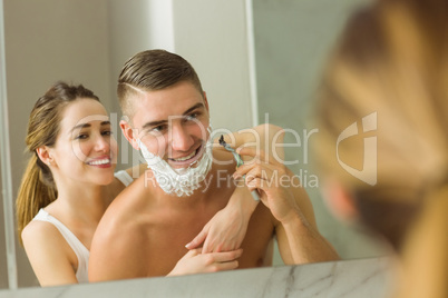 Woman putting shaving foam on boyfriends face