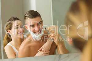 Woman putting shaving foam on boyfriends face