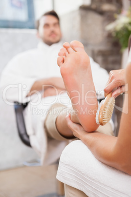 Pedicurist massaging customers foot