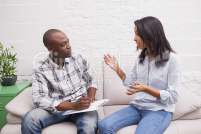 Woman sitting while therapist looking at her