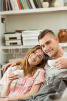 Cute couple relaxing on couch with coffee