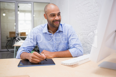 Man working at desk with computer and digitizer