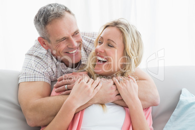 Content man hugging his wife on the couch