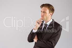 Young businessman thinking with hand on chin