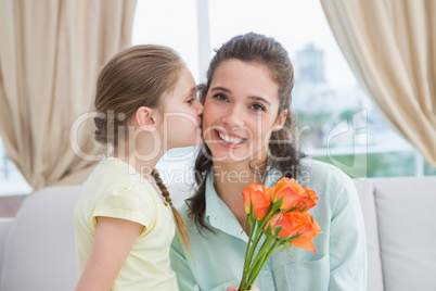 Cute girl giving flowers to mother