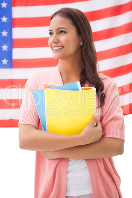 Pretty student smiling holding notebooks