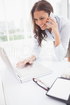 Happy businesswoman using laptop at her desk