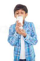 Cute boy drinking glass of milk