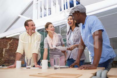 Casual business team smiling together at desk