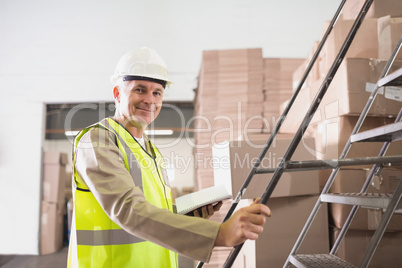 Worker with diary in warehouse