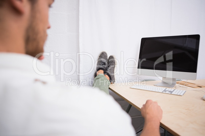 Businessman with legs crossed at ankle on office desk