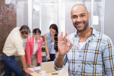 Happy businessman making okay gesture