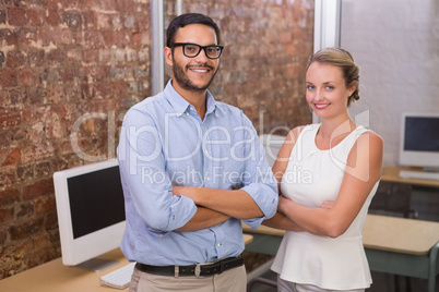 Confident business people with arms crossed in office