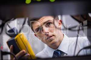 Technician using digital cable analyzer on server