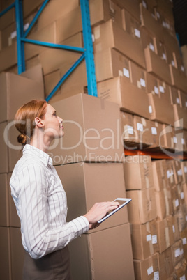 Female manager using digital tablet in warehouse