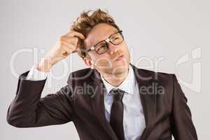 Young geeky businessman scratching his head