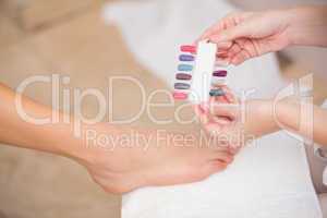 Beautician showing client nail colours