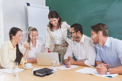 Casual business team having a meeting using laptop