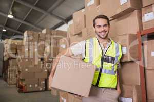 Worker carrying box in warehouse