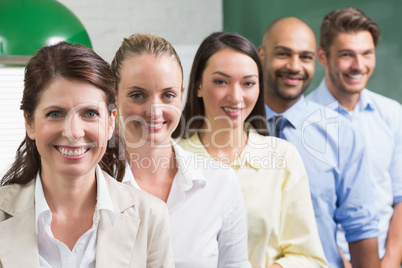 Business team standing in a row smiling at camera