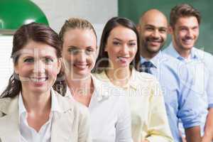 Business team standing in a row smiling at camera