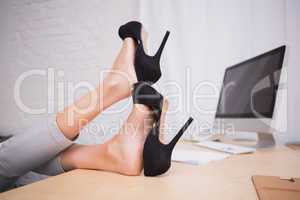 Businesswoman with high heels on desk