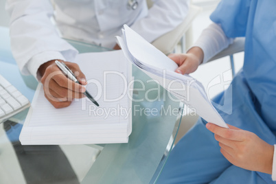 Doctor and surgeon reviewing notes