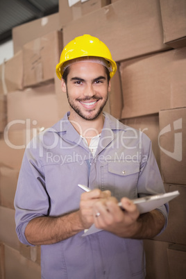 Worker with clipboard in warehouse