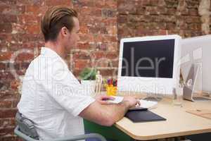 Creative worker typing on laptop at his desk