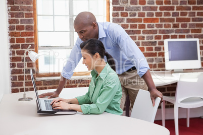 Casual business team working together with laptop