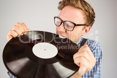 Geeky hipster biting vinyl record