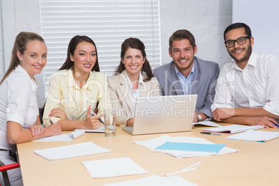 Casual business team having a meeting using laptop