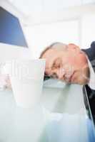 Exhausted businessman asleep at work