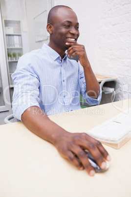 Cheerful creative businessman working on computer