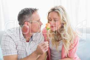 Couple relaxing on the couch with girl smelling flower