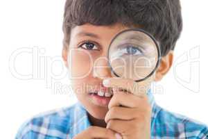 Cute boy looking through a magnifying glass