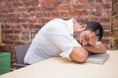 Businessman sleeping by laptop at desk Businessman sleeping by laptop at desk
