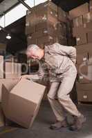 Worker with backache while lifting box in warehouse