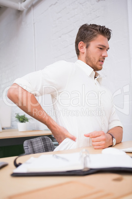 Businessman suffering from backache at office desk